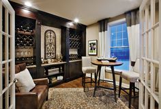 a living room filled with furniture and a wine rack on the wall next to a window