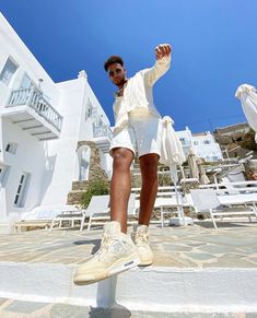 a man in white shorts and sneakers standing on steps