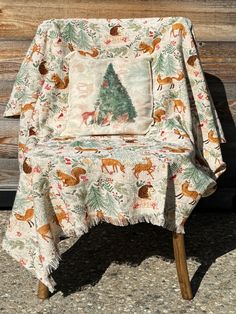 a chair with a christmas tree and deer on it sitting in front of a wooden wall