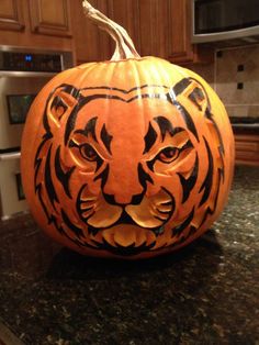 a carved tiger pumpkin sitting on top of a kitchen counter