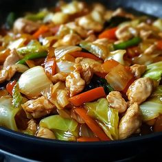 stir fry with chicken, carrots and celery in a skillet on the stove