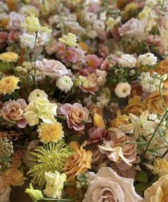 a bunch of flowers that are in some kind of vase on a table with other flowers