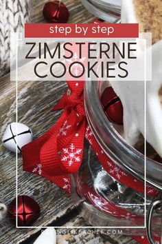 a glass jar filled with cookies on top of a wooden table next to christmas decorations