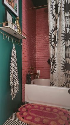 a bath tub sitting next to a red brick wall in a bathroom with a rug on the floor