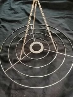 a metal object on a black cloth with chains hanging from it's center circle