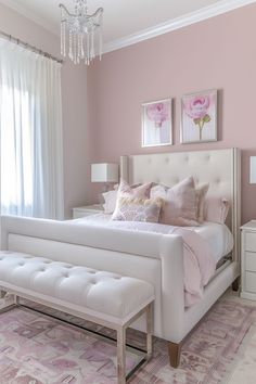 a white bed sitting in a bedroom next to a chandelier on a wall