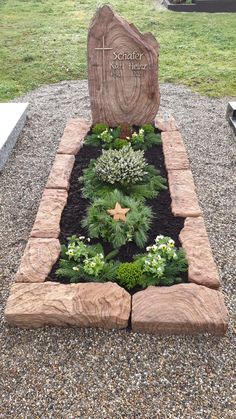 a garden in the shape of a tombstone with flowers and plants growing out of it