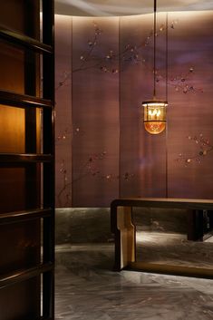 a wooden bench sitting under a light fixture in a room with wood paneled walls