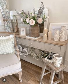 a white chair sitting next to a table with flowers on top of it and candles