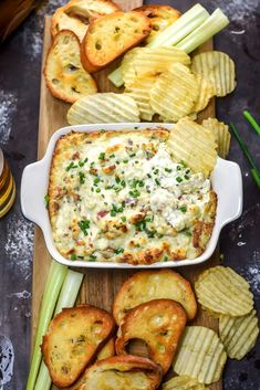 an appetizer with chips and dip on a cutting board