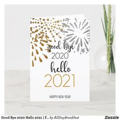 a new year card with gold and silver glitters on it, next to a potted plant