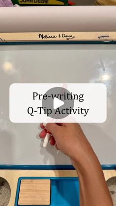 a person writing on a white board with the words pre - writing q - tip activity