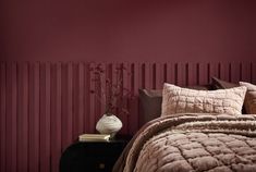 a bedroom with red walls and brown bedding