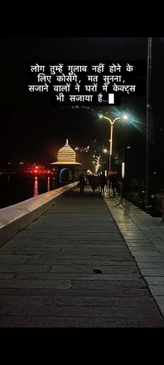 a person walking down a sidewalk at night with a quote written in english on it