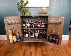 a wooden cabinet filled with bottles and glasses