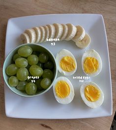 an egg, sliced bananas and grapes on a white plate with words labeled in english