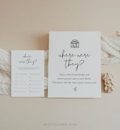 the wedding stationery is laid out on top of a white table cloth and two cards