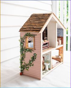 a doll house is shown with ivy growing on the roof and inside it's windows