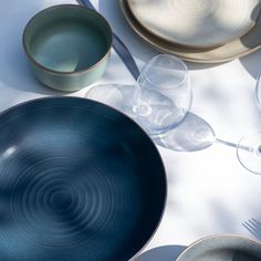 a table topped with plates and glasses on top of a white table cloth next to utensils