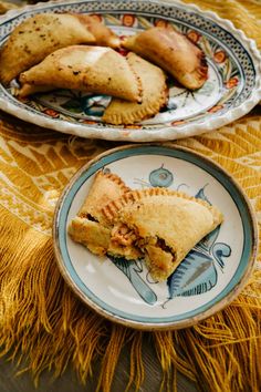 two plates with pastries on them sitting next to each other in front of a yellow table cloth