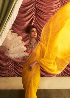 Wrap yourself in the sunshine hues of this stunning Yellow Organza Saree, perfect for making a statement at any festive event. The lightweight organza fabric drapes effortlessly, allowing you to move with grace while ensuring you’re the center of attention at any celebration. Paired with a beautifully embroidered red blouse, this saree is a showstopper for mehendi, sangeet, haldi ceremonies, or any wedding guest looking to add vibrant elegance to their look. Composition : Saree & Blouse - Georgette, Organza, Petticoat - Satin Lycra & Lining - Satin Care: Dry Clean Only and Vacuum Storage This product can be customized for sleeves, blouse length and neckline Delivery : 4-6 weeks as the product is hand crafted. Check Size Guide or choose MySize for free customisation (All Sizes above XL can Traditional Organza Pre-draped Saree For Party, Elegant Organza Blouse For Navratri, Festive Bollywood Organza Blouse, Organza Party Wear Blouse For Reception, Organza Blouse For Reception Party Wear, Organza Party Wear Blouse For Wedding, Festive Party Silk Chiffon Pre-draped Saree, Festive Party Pre-draped Silk Chiffon Saree, Party Blouse In Organza With Traditional Drape