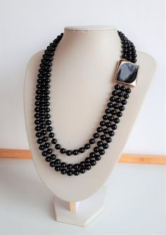 Elegant and chic MICHELE LYNN signed black lucite plastic 3 graduated rows beaded necklace with big gold and black modern rectangular shape enamel clasp. Signed on the clasp on the back. Good condition. Longest row: 23 inches; shortest row: 19.5 inches; beads: 7 mm; clasp: 1-3/8 x 1-1/8 x 1/8 inches.  IMPORTANT TO READ: To make this a smooth and pleasant transaction experience for everyone, all buyers need to read and understand the description, the terms of sale , the payment and the shipping indicated in this listing. TERMS OF SALE A. SHIPPING WORLDWIDE This listing includes payable tracked services with the fees indicated below. B. CARRIERS We don't ship with FedEx, DHL or UPS or any other carrier except for Canada Post unless a specific agreement with the buyer is accepted by us at our Black Enamel, Stone Bracelet, Necklace Gold, Gold Black, Costume Jewelry, Jewelry Inspiration, Etsy Vintage, Favorite Jewelry, Gold Necklace