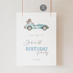 a birthday party sign with a blue race car and checkered flag on the front