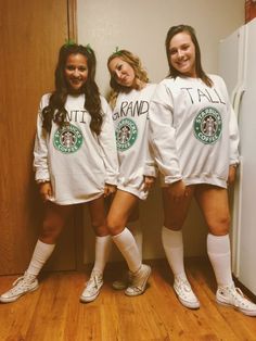 three girls in matching outfits standing next to a refrigerator