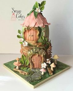 a cake that is made to look like a fairy house with mushrooms and flowers on it