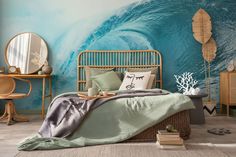 a bedroom with a blue wave painted on the wall and bed in front of it