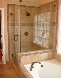 a bath tub sitting inside of a bathroom next to a walk in shower and window