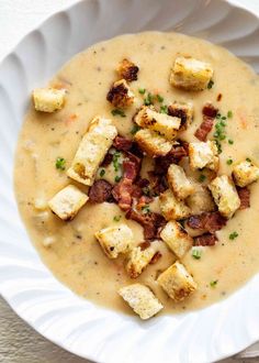 a white bowl filled with soup and croutons