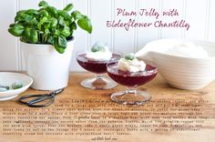 two glasses filled with dessert sitting on top of a wooden table next to a potted plant