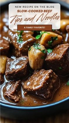 a bowl filled with beef and vegetables on top of a wooden table