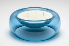 a blue glass candle holder sitting on top of a white table