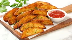 potato wedges on a cutting board with ketchup and parsley