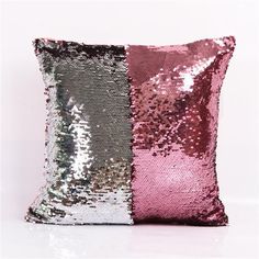 a pink and silver sequinized pillow on a white background with the same color