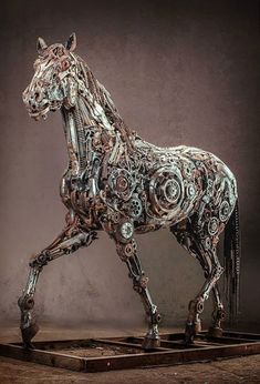 a sculpture of a horse made out of gears and other mechanical parts is shown in front of a dark background