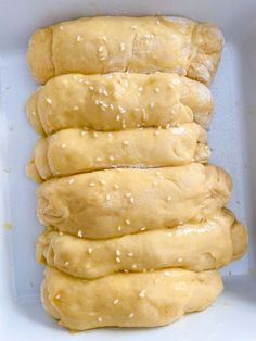 a white container filled with bread rolls covered in sesame seeds