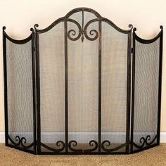 an iron fireplace screen is shown in the corner of a room with beige carpeting