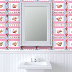 a bathroom sink sitting under a mirror next to a wall mounted medicine cabinet with flowers on it