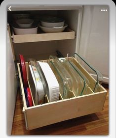 an open drawer with dishes in it