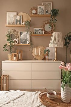 a white dresser topped with vases filled with flowers