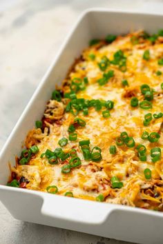 a casserole dish with green onions and cheese