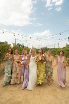 a group of women standing next to each other in front of a string of lights