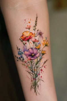 a colorful flower tattoo on the left arm and leg, with watercolor flowers painted all over it