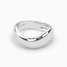 a white gold wedding ring on a plain surface, with the center band slightly open