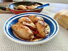 some food that is on a blue and white plate next to a loaf of bread