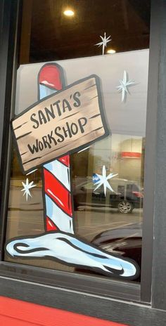 a sign that says santa's workshop in front of a window