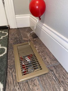 a floor grate with a red balloon attached to it